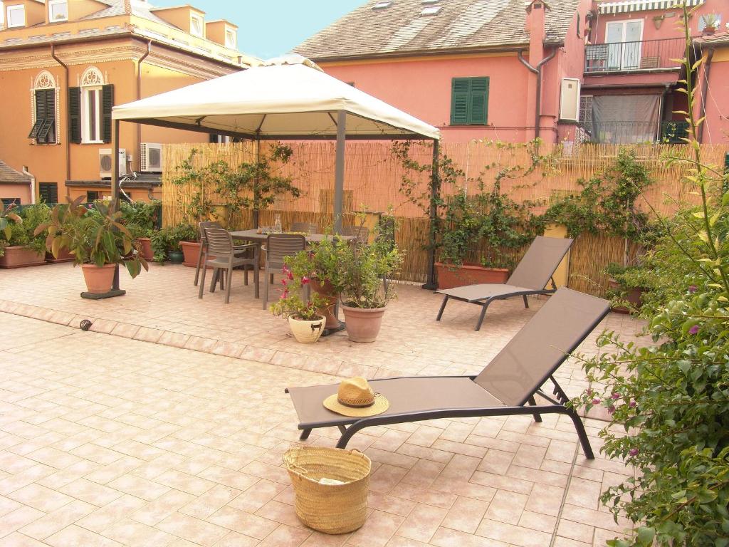 莱万托Residenza Cavour - Appartamento AGAVE的庭院配有桌子、遮阳伞和椅子