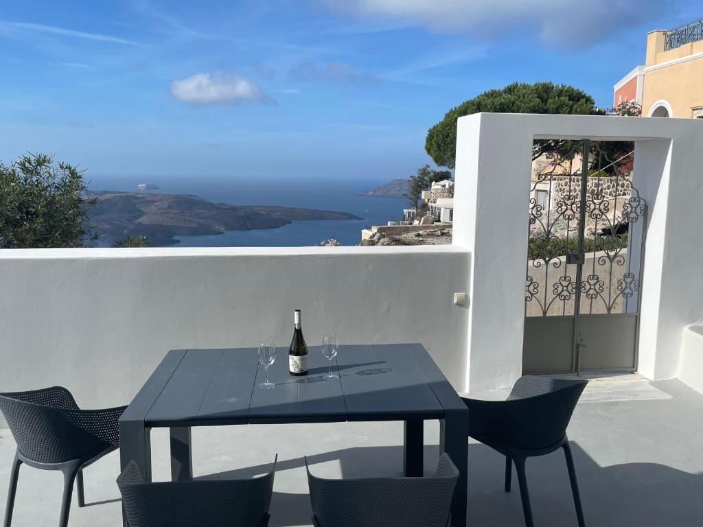 费拉Villa DALI Danae的阳台上的桌子和一瓶葡萄酒
