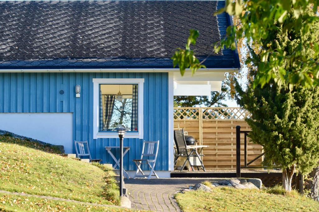 奥克什贝里亚Sjöstuga/gästhus i skärgården.的前廊的蓝色房子,带椅子