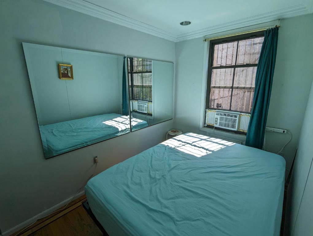 布鲁克林Fawlty Towers的一间小卧室,配有一张床和镜子