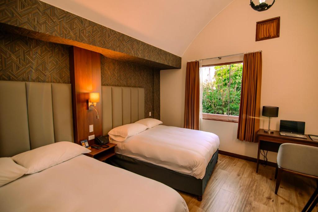 阿雷基帕La Maison d'Elise的酒店客房设有两张床和窗户。