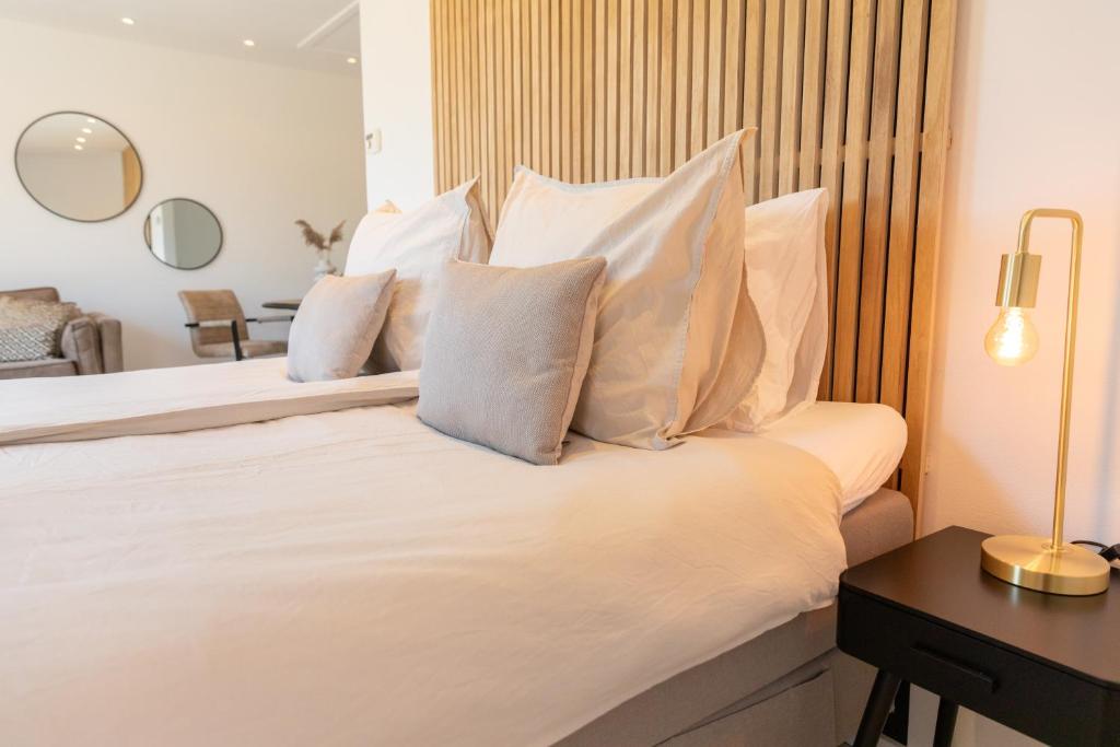登堡Bed & Bike Op Texel的卧室配有白色的床铺和白色的枕头