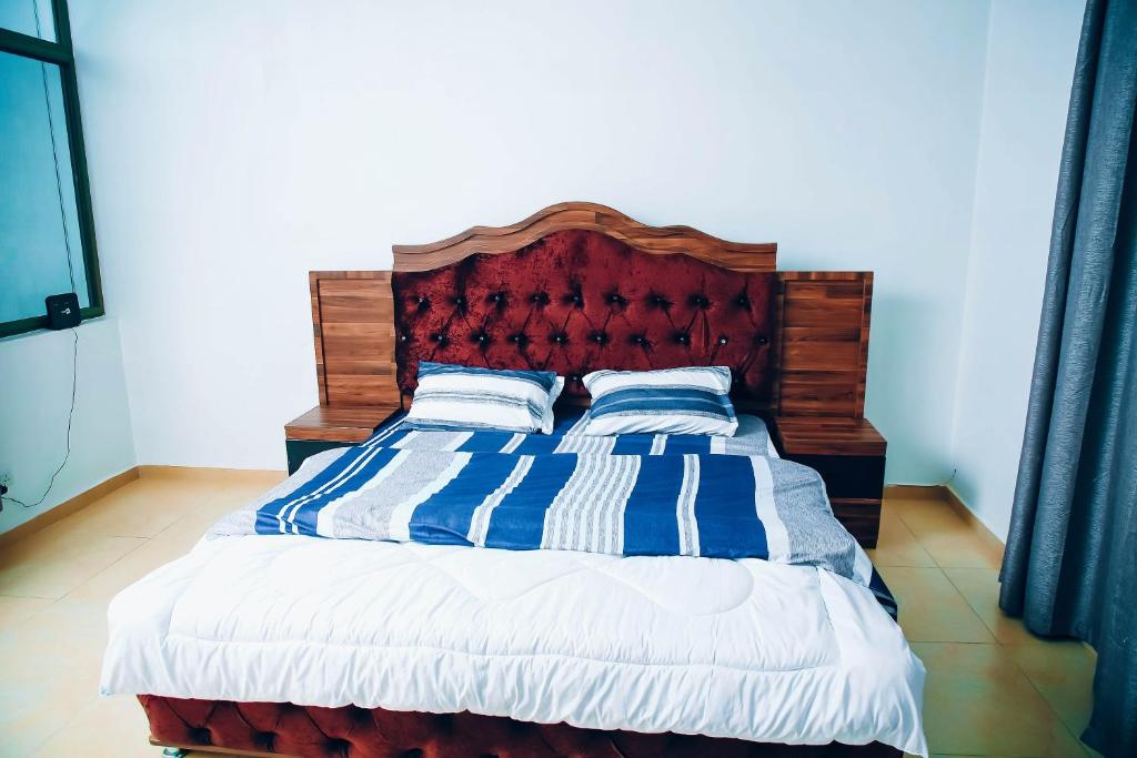 BugeseraSaint Emmanuel near Kigali Convetion center的一张带蓝色和白色条纹毯子和枕头的床