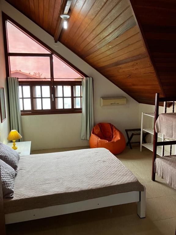 伊比拉奎拉Townhouse composta por 4 triplex duas suítes a duas quadras do mar的一间卧室设有一张床和一个大窗户
