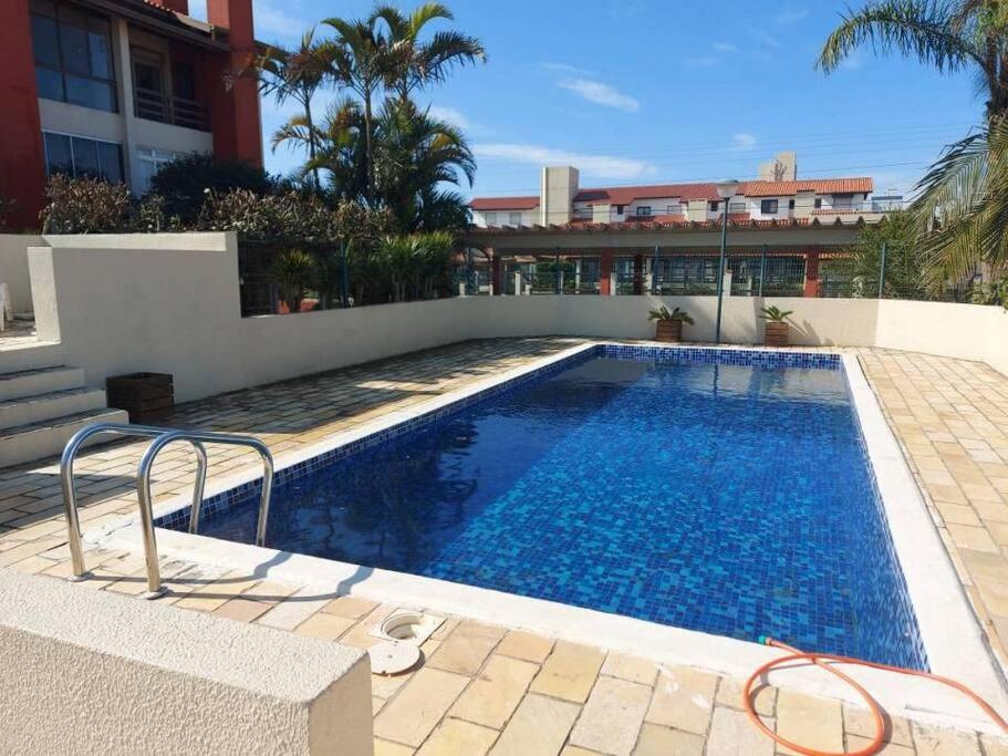 卡庞达卡诺阿Apartamento em Capão Novo com piscina的一座建筑物旁边的游泳池