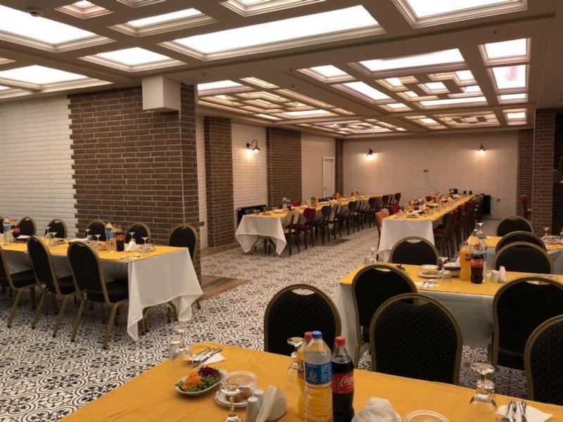 萨姆松GRAND DELUX HOTEL的大型宴会厅配有桌椅和食物