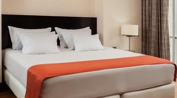 查查波亚斯Hostal Kollarón的一间卧室配有一张大白色床和橙色毯子