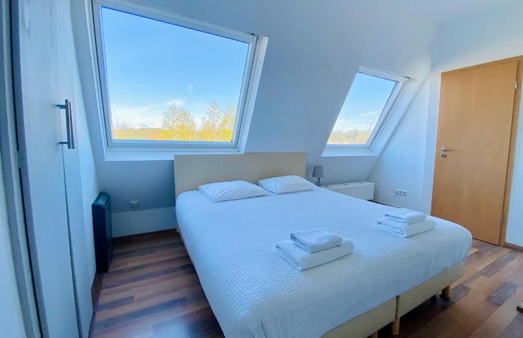 卢森堡阿拉米斯一室公寓公寓式酒店的卧室配有白色的床和2条毛巾