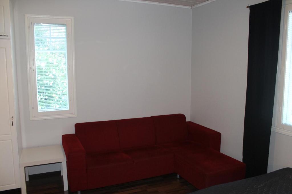 OulunsaloOulunsalo Apartment的带2扇窗户的客房内的红色沙发