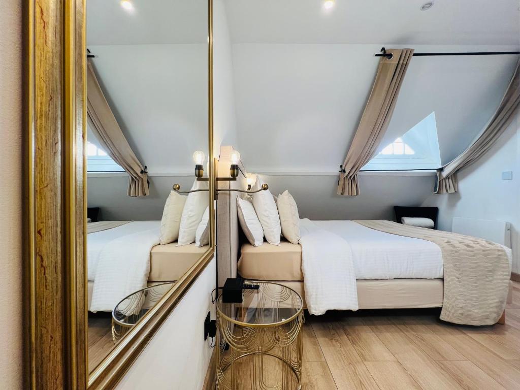 Ris-OrangisSuperbe appartement avec jardin et parking privé的一间卧室配有两张床和镜子