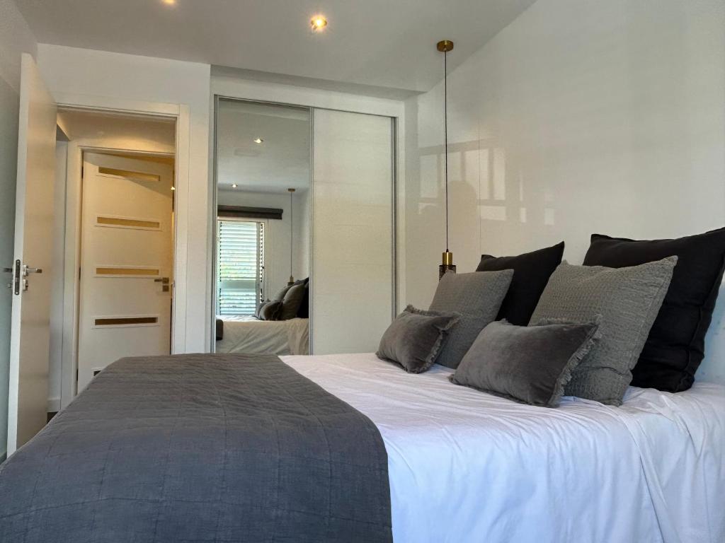 圭马尔港Puertito Beach Suites 1的卧室配有一张带灰色枕头的大床
