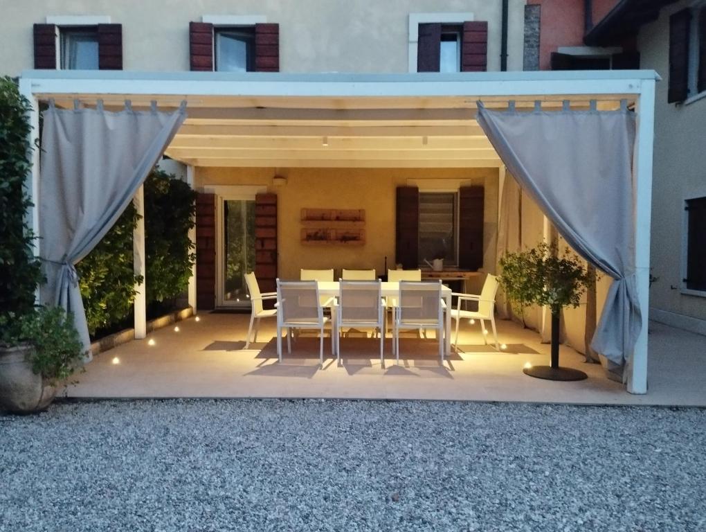 维罗纳Appartamento La Corte Verona的一个带帐篷的庭院内的桌椅