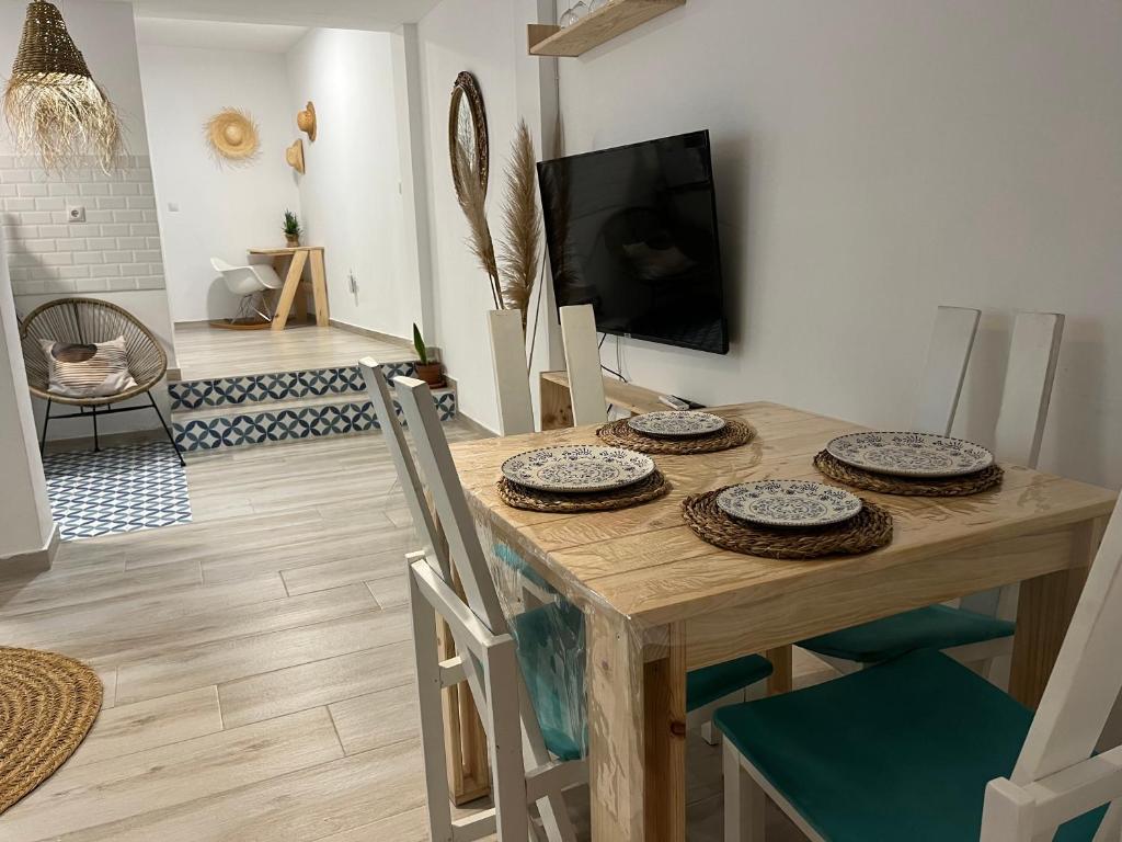 阿尔齐拉Alzira bonita Apartamento B con patio, la Casella的一间带桌椅和电视的用餐室