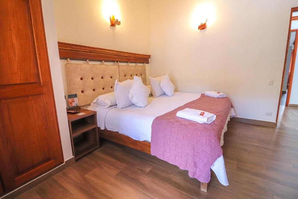 莱瓦镇Hotel las Palmas的酒店客房配有一张床铺和一张桌子。