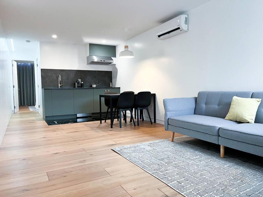 布鲁克林New Cozy Modern Minimalist Stay in Brooklyn at Rem-Casa的一间带蓝色沙发的客厅和一间厨房
