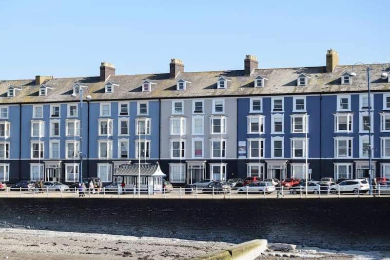 阿伯里斯特威斯Luxury Seaside accommodation, Swn Y Mor的靠近水体的蓝色大建筑