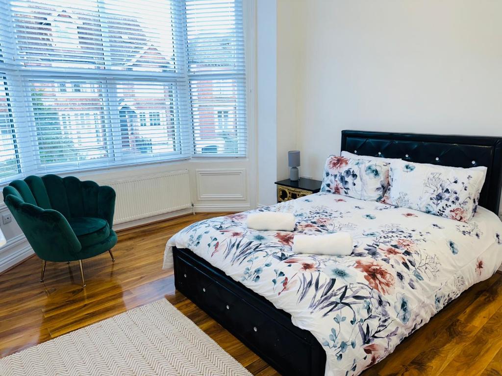 圣伦纳兹Newly refurbished two bedrooms flat的一间卧室配有一张床、一把椅子和窗户。