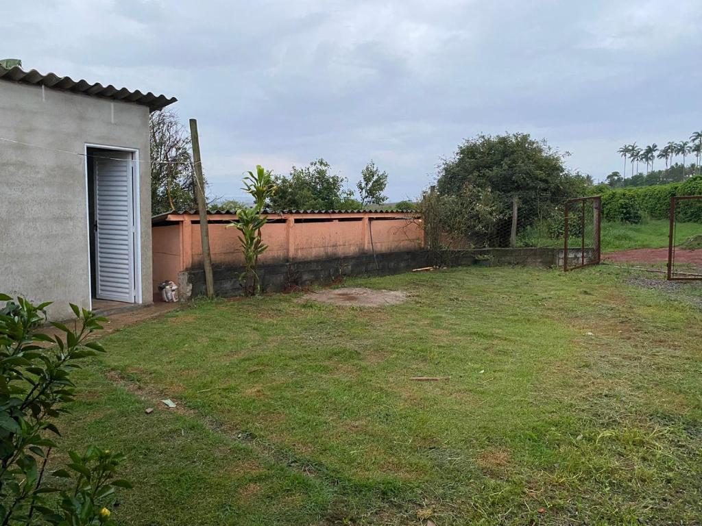 圣罗克迪米纳斯CAMPING SÃO BENEDITO的后院设有栅栏和草地庭院