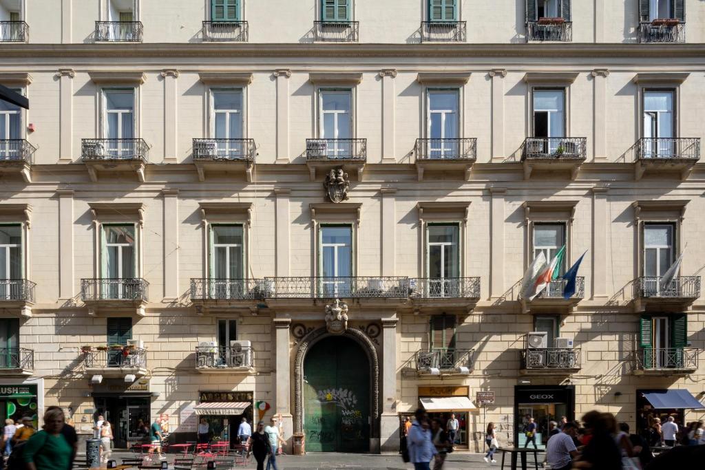 那不勒斯Napolit'amo Hotel Principe的一座大型建筑,前面的人在步行