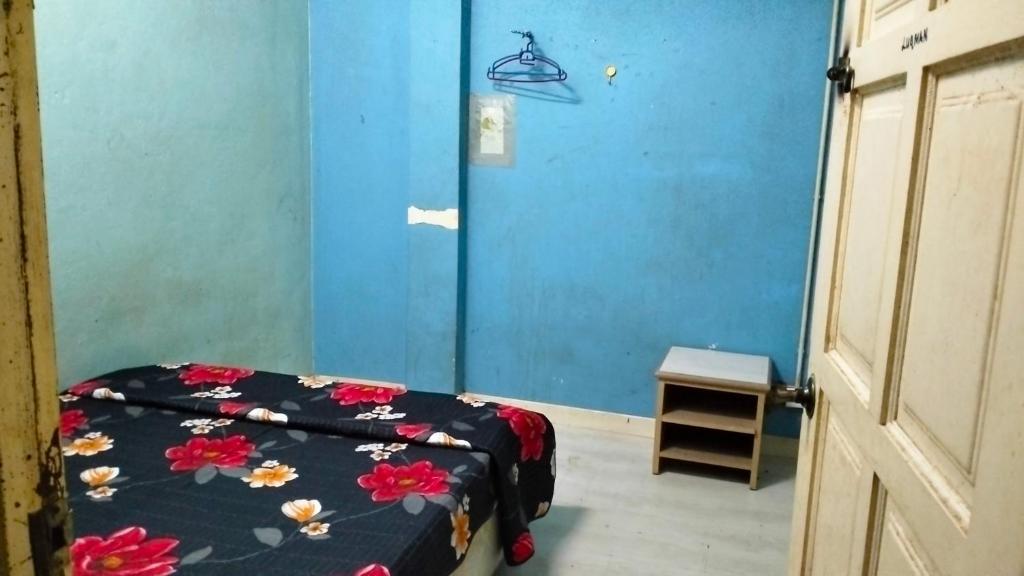 哥打巴鲁Hostel Dena moon inn 3的一间卧室设有一张床和蓝色的墙壁