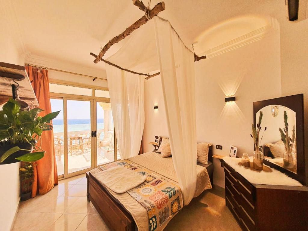 达哈布Lucky palace Dahab的一间卧室设有一张天蓬床,享有海景