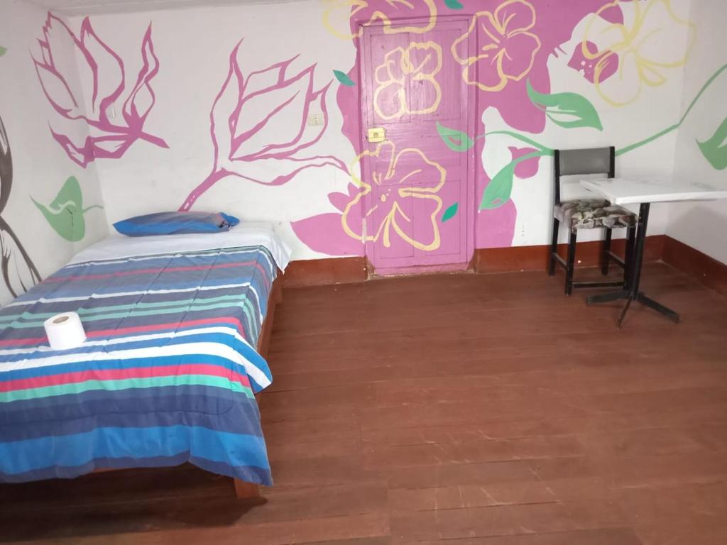 查查波亚斯DEJAVU的一间设有床铺和鲜花的墙壁的房间
