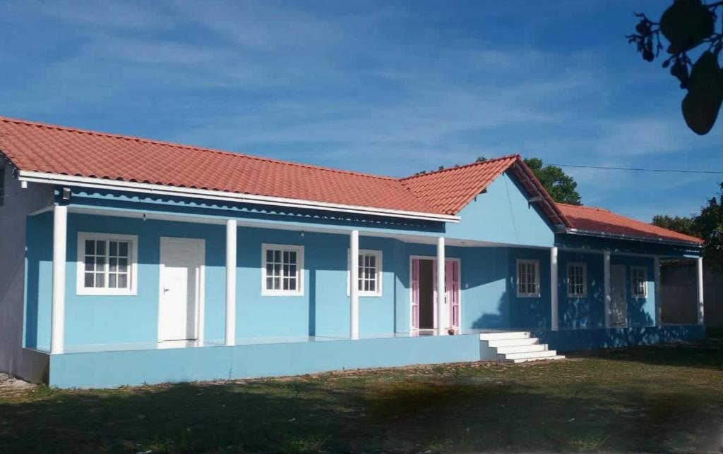 伊塔帕里卡岛维拉克鲁兹Pousada Raio de Sol - Ilha de Itaparica- Catu á 150 m da praia的蓝色和白色的房屋,有红色屋顶