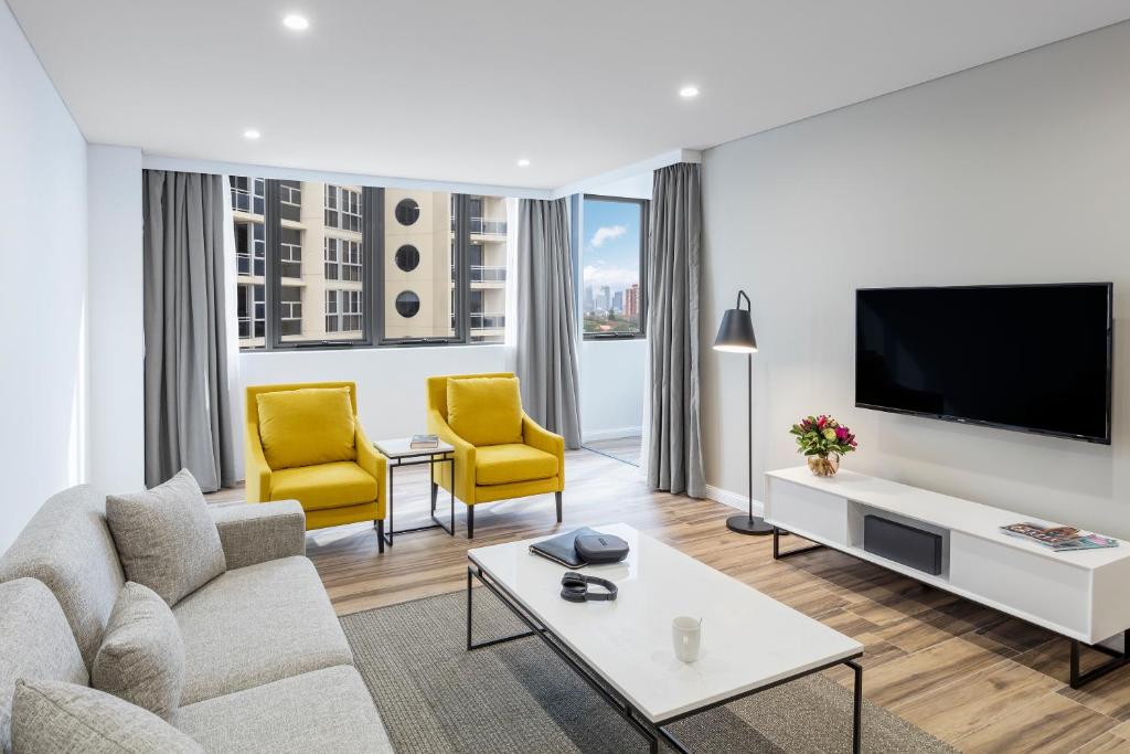 悉尼邦迪交界处美利通公寓式酒店的客厅配有沙发和2把黄色椅子