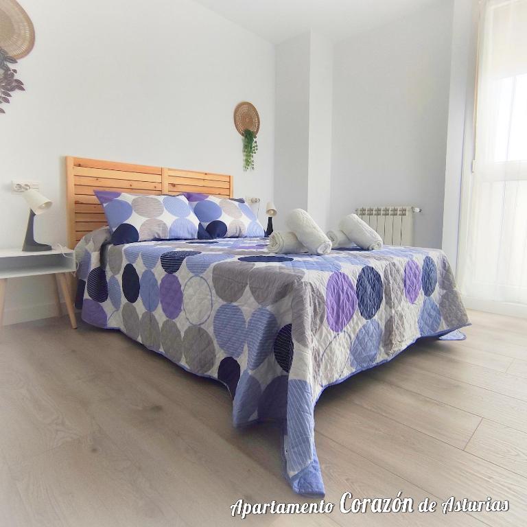 彼德拉斯布兰卡斯CORAZÓN DE ASTURIAS的一间卧室配有一张带蓝色和紫色棉被的床