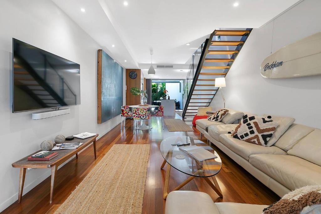 布里斯班The Sun Catcher - A Trendy South Brisbane Terrace的带沙发和电视的客厅