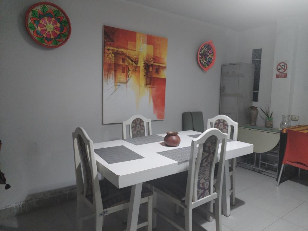 卡哈马卡CASA HOSTEL 129-A的一间配备有白色桌椅的用餐室