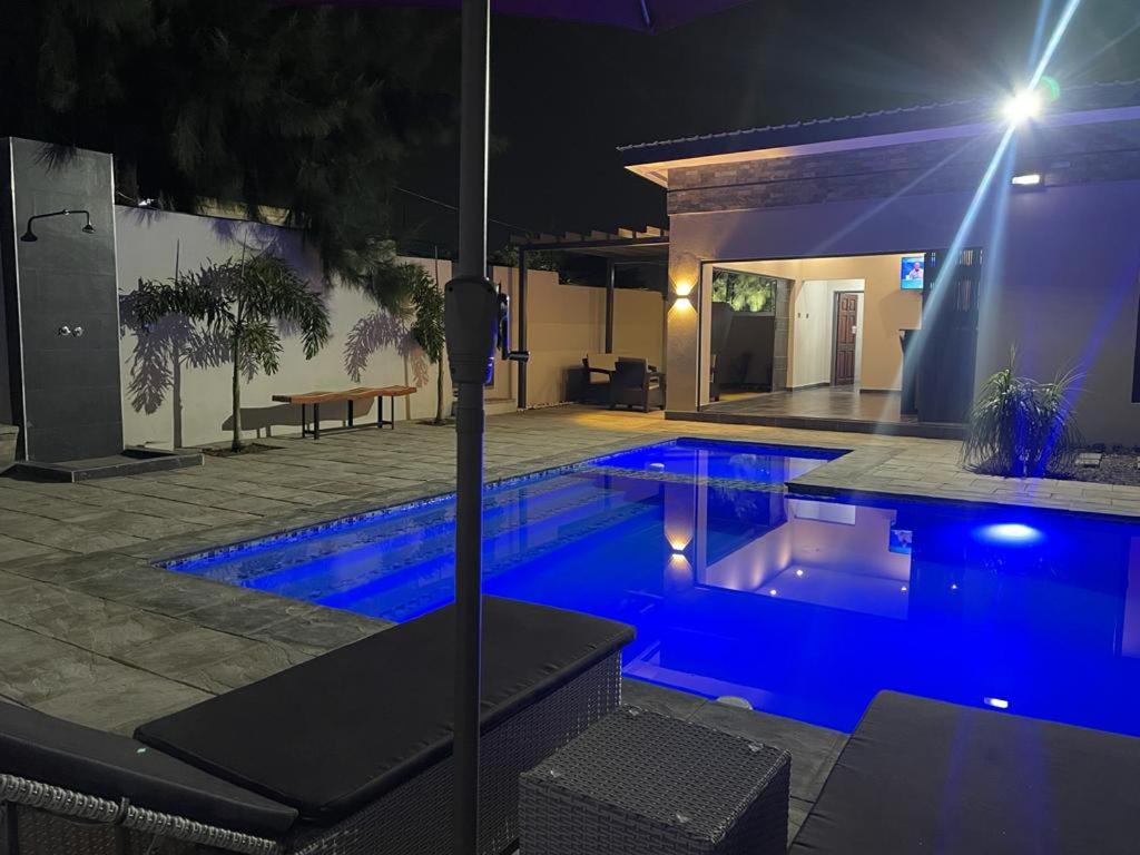 卢萨卡Meanwood Place Apartments的夜间游泳池与房子