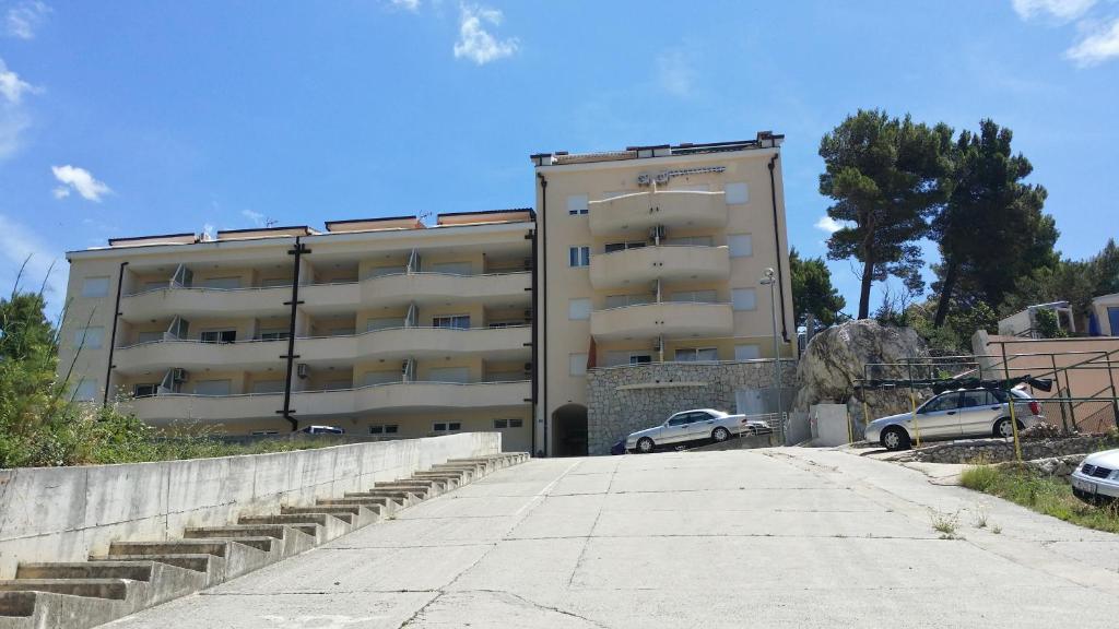 巴什卡沃达Apartments Mediteraneo的一座大型建筑,前面有汽车停放