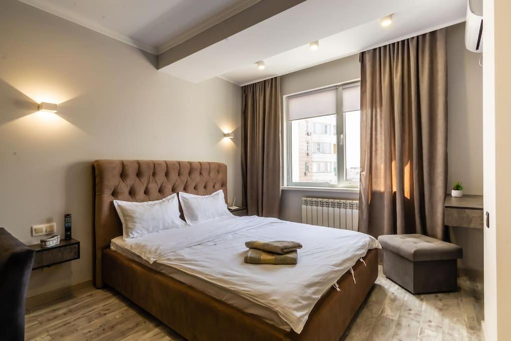 阿拉木图Apartments golden Square 162的一间卧室设有一张大床和一个窗户。