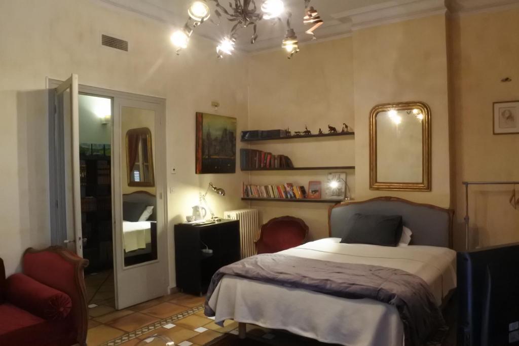 佩皮尼昂Bartissol et Maillol的一间卧室配有一张床、镜子和椅子