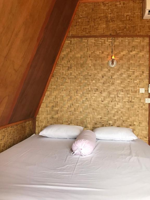 KotarajaMuni's Terrace Bungalow的一张带两个白色枕头和砖墙的床
