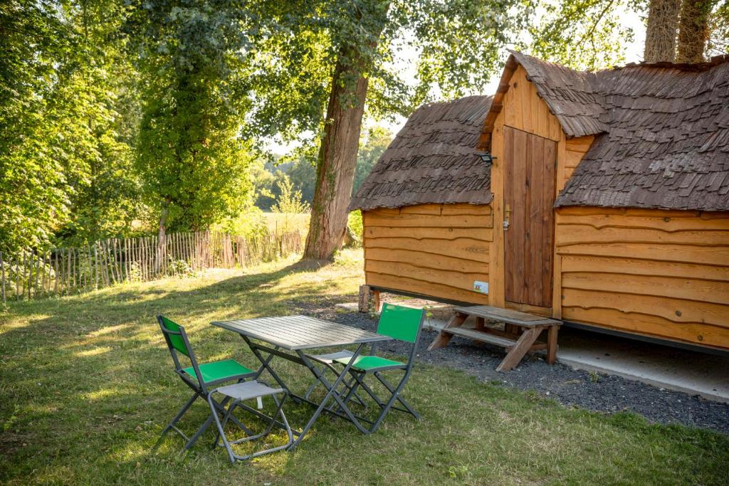 ContyLa cabane magique的小屋前的野餐桌和椅子