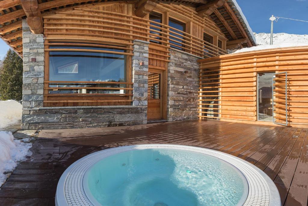阿亚斯Lavarets Chambres d’Hôtes的木屋前的大型热水浴池