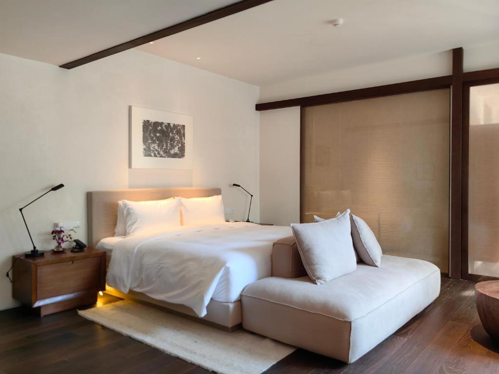 苏州苏州畅园有熊酒店的卧室配有白色的床和沙发