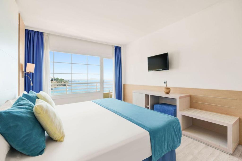 帕尔马诺瓦Hotel Agua Beach "Adults only"的一间卧室设有一张床和一个大窗户