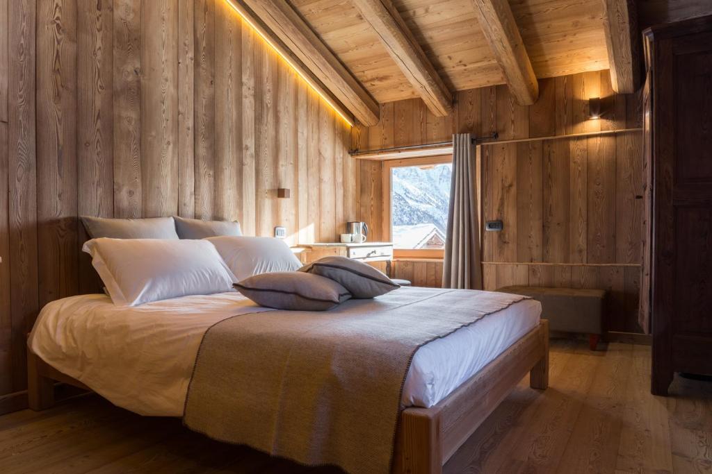 阿亚斯Lavarets Chambres d’Hôtes的卧室配有一张木墙内的大床