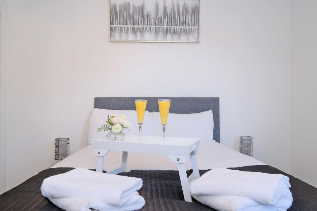 阿伯丁Orange Apartments Belgrave Mansions的一张带白色桌子和两杯眼镜的床