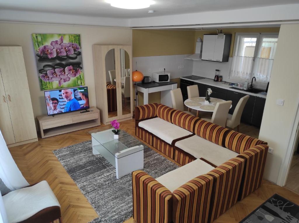 基什孔豪洛什SIESTA vendégház的一间带两张沙发的客厅和一间厨房