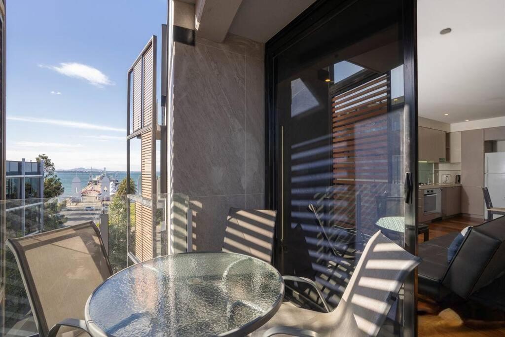 吉朗Beachfront Bliss: Luxury Living的阳台上的玻璃桌子和椅子