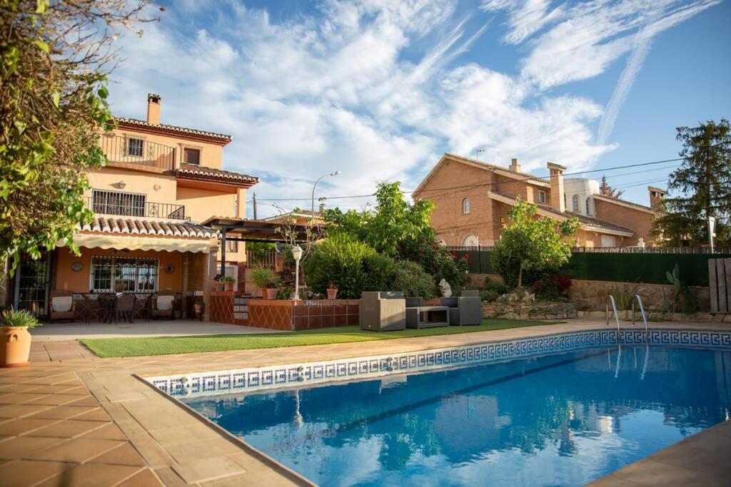 拉苏维亚Casa espaciosa cerca de Monachil的庭院中带游泳池的房子