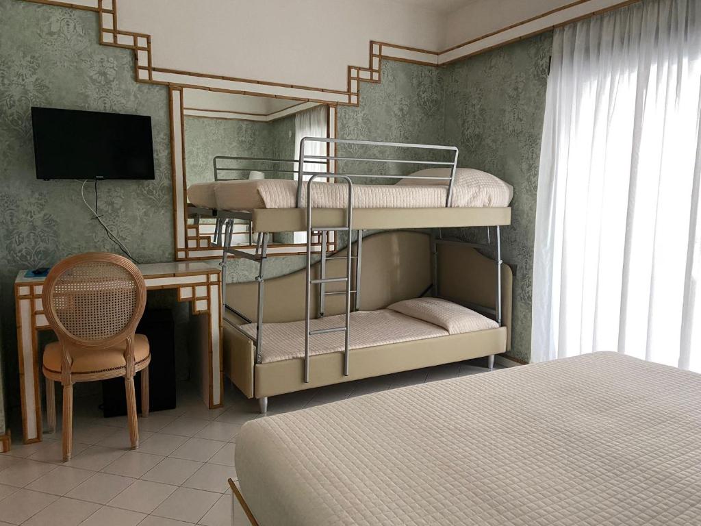 里乔内Hotel President - Vintage Hotel in centro的一间卧室配有两张双层床和一张书桌