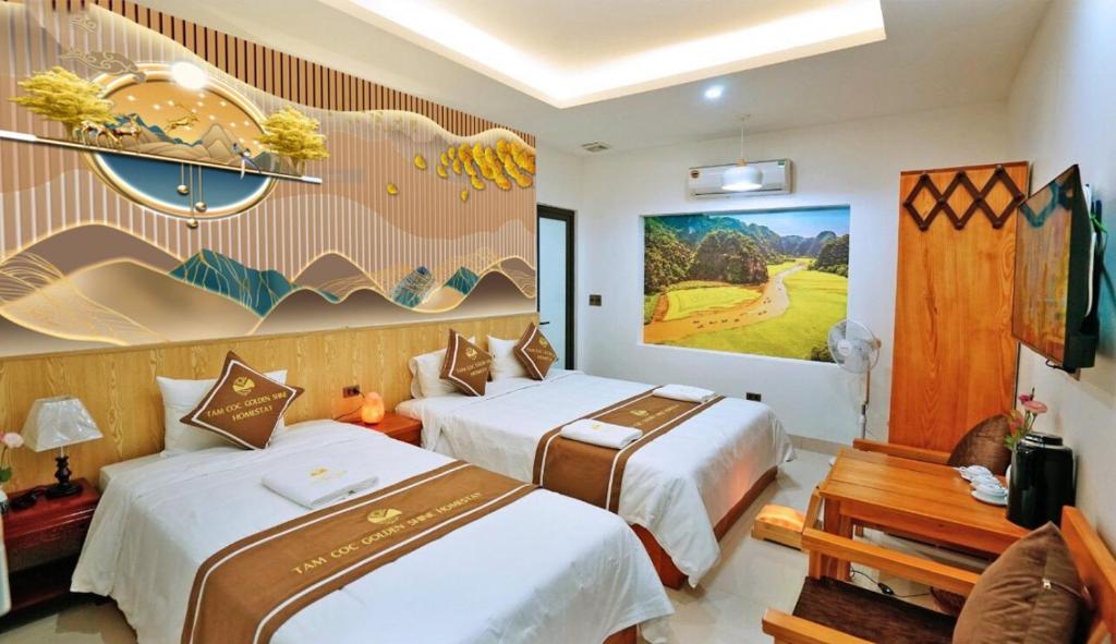 宁平TamCoc Golden Shine Homestay的酒店客房设有两张床,墙上挂有绘画作品