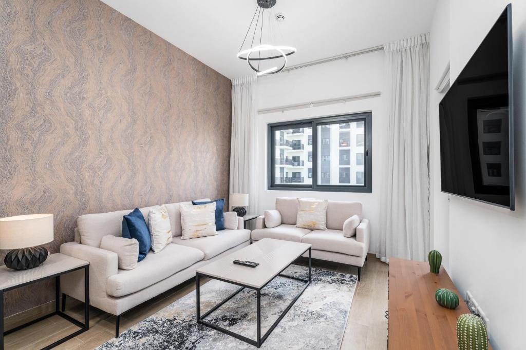 迪拜Nasma Luxury Stays - Home-Style 2BR Apartment with a Balcony View的客厅配有沙发和桌子