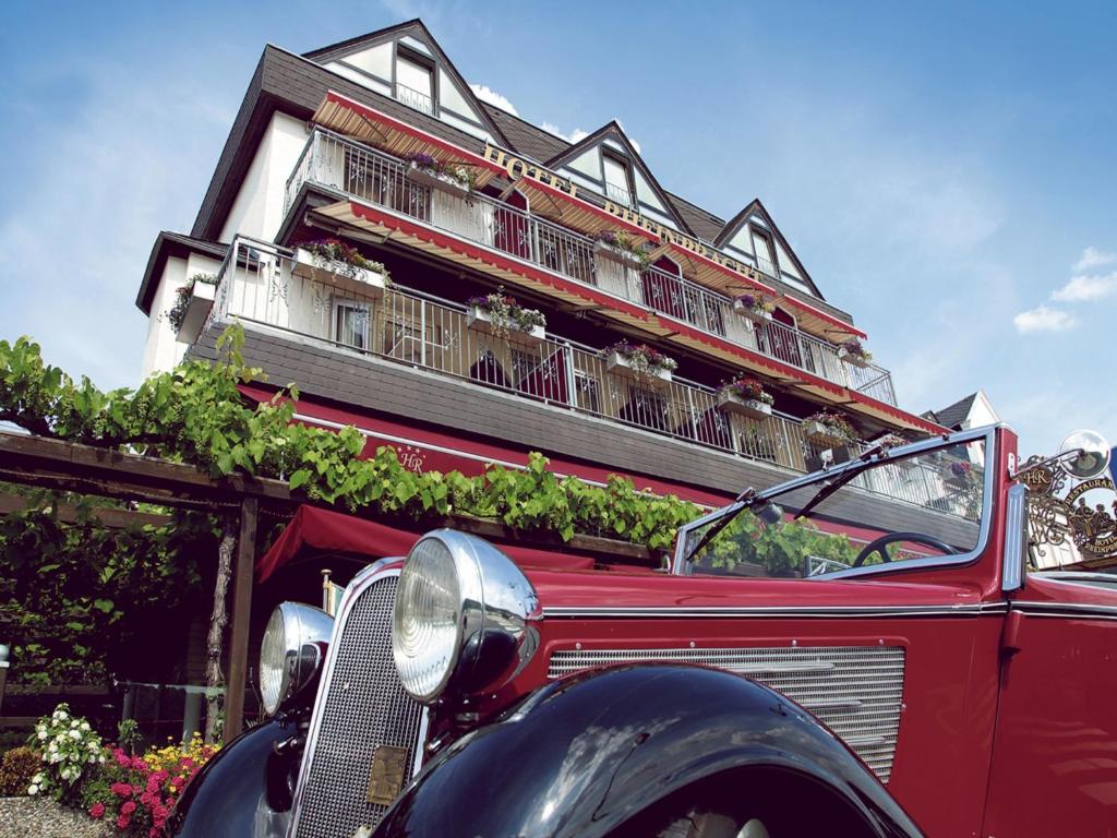 坎普-博尔恩霍芬Hotel Garni Rheinpracht的停在大楼前的一辆旧红色汽车