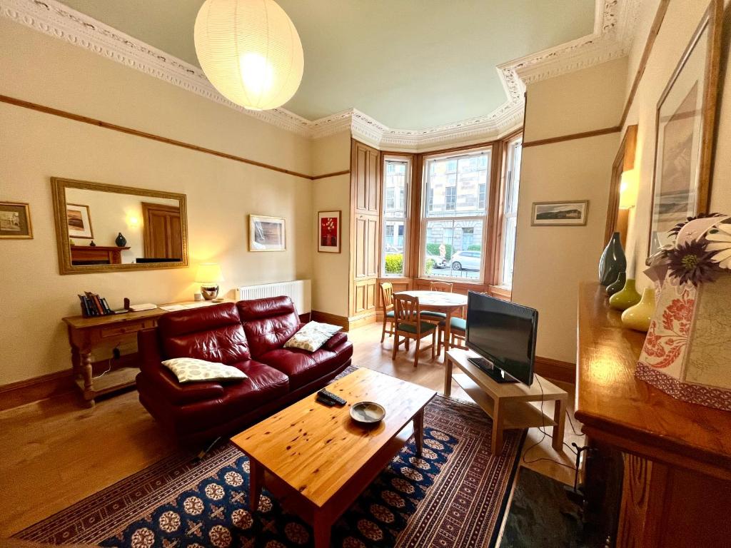 爱丁堡Beautiful Spacious Ground Floor Newington flat的客厅配有沙发和桌子